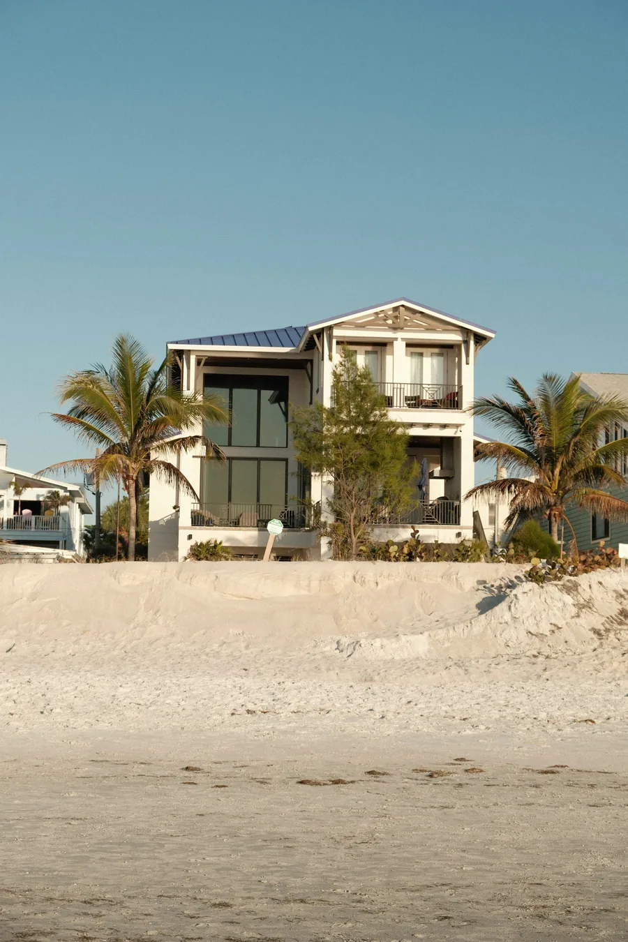 A beachfront house with weathered siding facing the dunes
